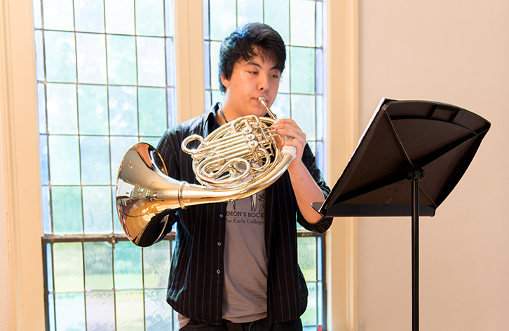 A student practices the French horn.