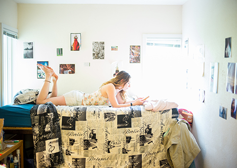 Student reading on bed in dorm