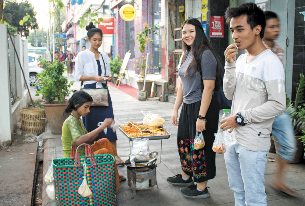 Students purchasing snacks from a street vendor